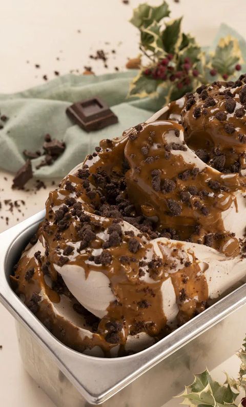 Plumcake gelato rettangolare in stampo metallico, con caramello e granella di cioccolato, contornato da agrifoglio e...