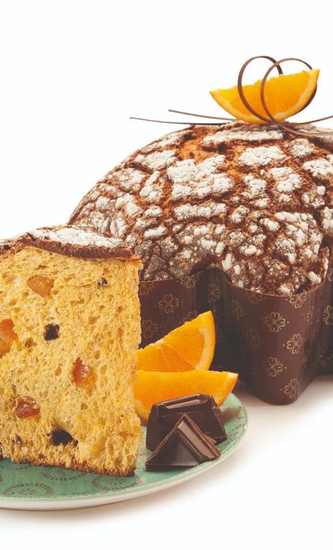 Colomba pasquale italiana con zucchero a velo, tagliata per mostrare i canditi, servita con spicchi d'arancia