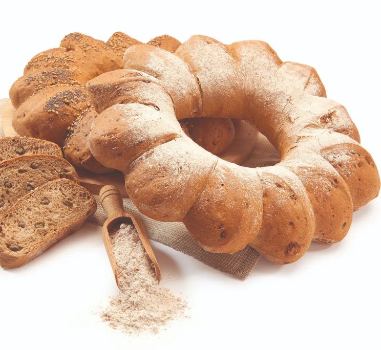 Pane intrecciato a ciambella spolverato di farina, con fette di pane ai semi e paletta di legno con farina.
