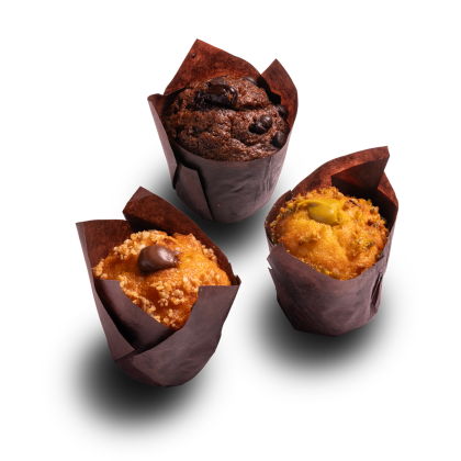 Tre muffin in pirottini marroni: gocce di cioccolato, caramello con cioccolato e pistacchio, su sfondo bianco