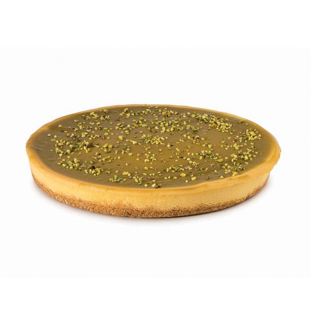 Crostata rotonda con glassa liscia al caramello, base biscottata e granella di pistacchio in superficie.