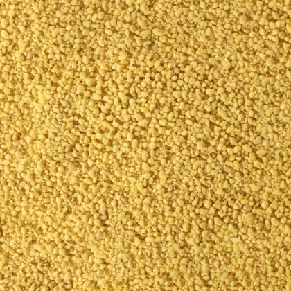 Primo piano di texture granulare gialla fine, simile a semola grossa o couscous secco.