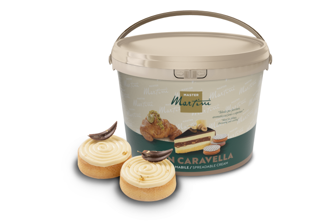 Secchiello di crema spalmabile Master Martini accanto a due dolci glassati con riccioli di cioccolato e glitter oro