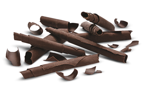 Riccioli di cioccolato fondente di varie dimensioni sparsi su sfondo bianco.