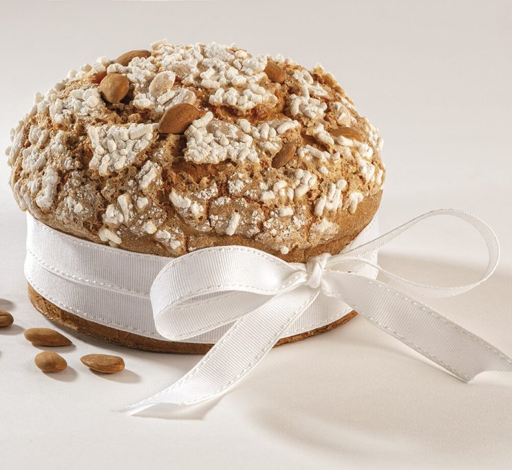 Torta rotonda italiana all'amaretto con glassa craquelé e mandorle, fiocco bianco.